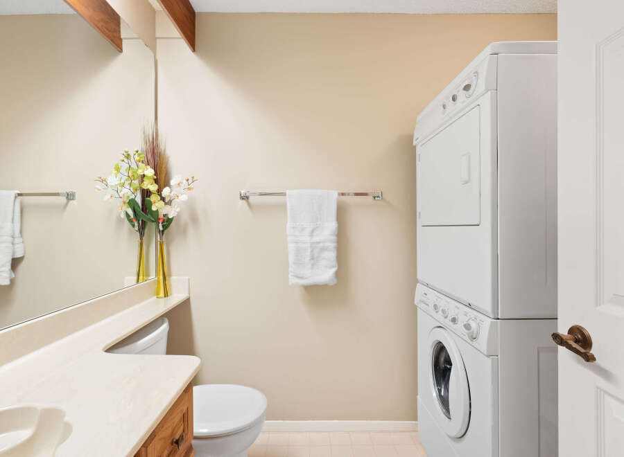 This bathroom features a stacked washer and dryer, perfect for maximizing space in a compact area.