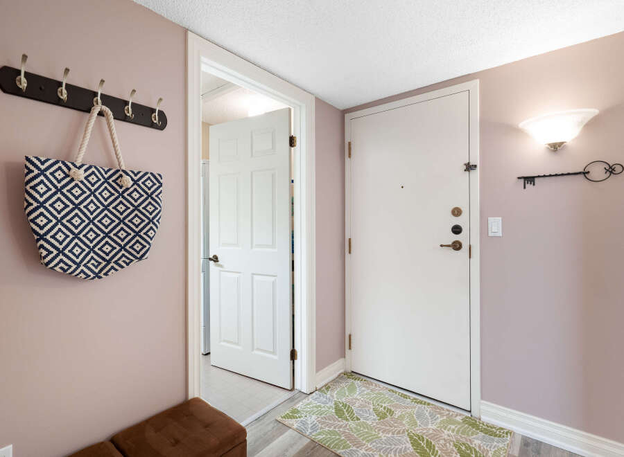 Welcome guests into this charming entryway featuring a stylish coat rack with a decorative tote bag, perfect for keeping essentials organized.