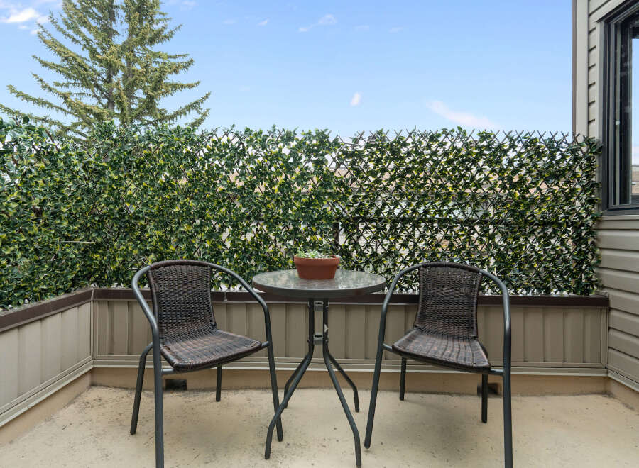 Enjoy your morning coffee or evening relaxation on this charming balcony, complete with a bistro set and privacy fencing.
