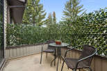 Enjoy your morning coffee or evening drink on this charming balcony, complete with a bistro set and a privacy screen of lush greenery.