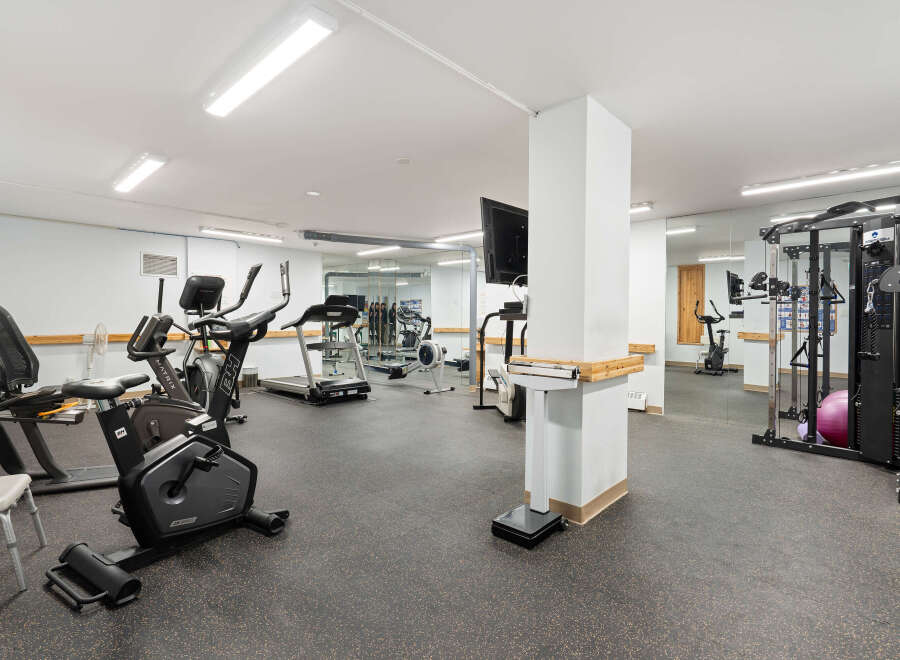 This well-equipped gym features a variety of cardio machines including treadmills, ellipticals, and stationary bikes, perfect for your fitness routine.