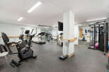 This well-equipped gym features a variety of cardio machines including treadmills, ellipticals, and stationary bikes, perfect for your fitness routine.