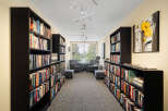 Step into this inviting library, featuring floor-to-ceiling bookshelves filled with a diverse collection of literature.