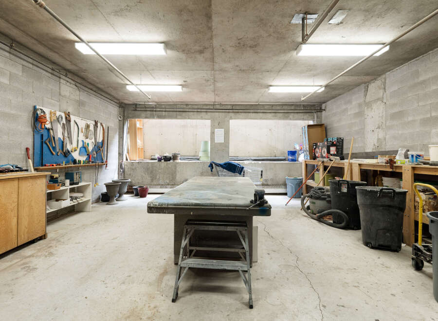 This spacious workshop features a large workbench, ample storage cabinets, and a well-organized tool wall, perfect for any DIY enthusiast or professional.