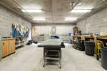 This spacious workshop features a large workbench, ample storage cabinets, and a well-organized tool wall, perfect for any DIY enthusiast or professional.