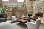 Experience cozy living in this inviting space featuring a rustic stone fireplace and comfortable seating.