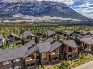 Experience modern mountain living in this stunning multi-unit property, featuring contemporary architecture with natural wood accents and dark siding.
