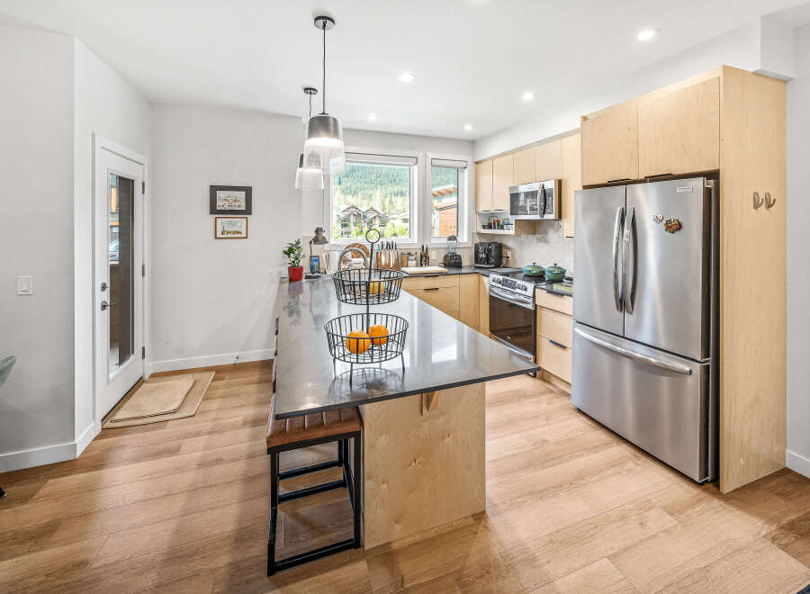 Experience modern living in this stunning kitchen featuring sleek stainless steel appliances, including a spacious refrigerator and microwave.