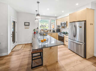 Experience modern living in this stunning kitchen featuring sleek stainless steel appliances, including a spacious refrigerator and microwave.