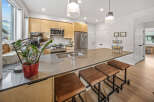Experience modern living in this stunning kitchen featuring sleek, light wood cabinetry and a spacious quartz island perfect for entertaining.