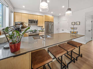 Experience modern living in this stunning kitchen featuring sleek, light wood cabinetry and a spacious quartz island perfect for entertaining.