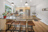 Experience modern living in this stunning kitchen featuring sleek cabinetry, a spacious island with bar seating, and top-of-the-line stainless steel appliances.