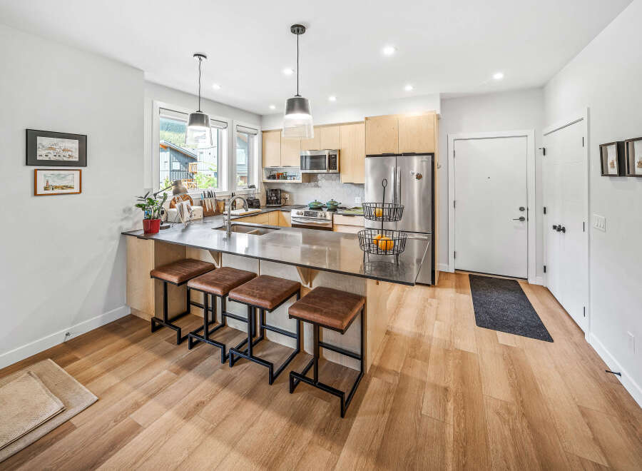 Experience modern living in this stunning kitchen featuring sleek cabinetry, a spacious island with bar seating, and top-of-the-line stainless steel appliances.