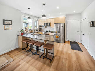 Experience modern living in this stunning kitchen featuring sleek cabinetry, a spacious island with bar seating, and top-of-the-line stainless steel appliances.