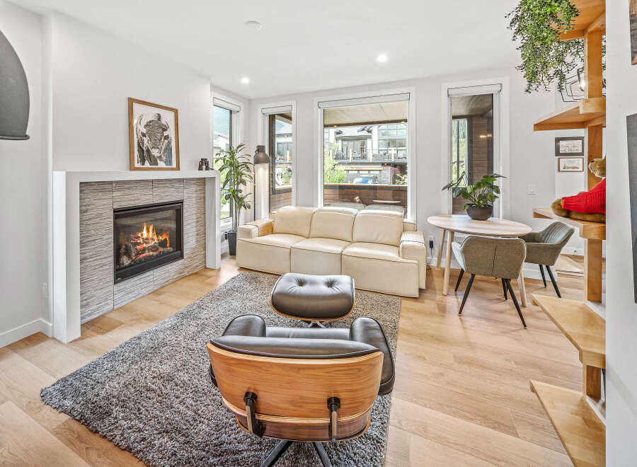 Experience modern living in this bright and airy living room, featuring a cozy fireplace and comfortable seating.
