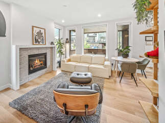 Experience modern living in this bright and airy living room, featuring a cozy fireplace and comfortable seating.