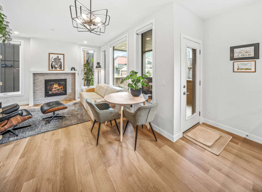 Experience modern living in this stylish living room featuring a cozy fireplace and a comfortable seating area.