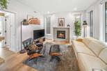 Experience modern living in this stylish living room featuring a cozy fireplace and a comfortable leather armchair with an ottoman.