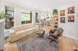 Experience modern living in this stunning open-concept space, featuring a sleek cream sofa and a stylish black leather lounge chair perfect for relaxation.