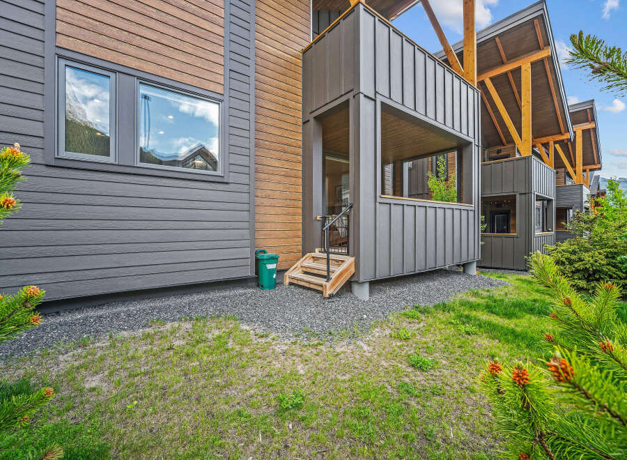 Experience modern mountain living in this stunning property featuring a unique blend of dark grey siding and warm wood accents.
