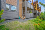 Experience modern mountain living in this stunning property featuring a unique blend of dark grey siding and warm wood accents.