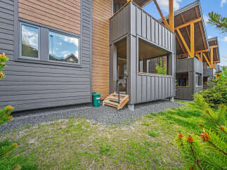 Experience modern mountain living in this stunning property featuring a unique blend of dark grey siding and warm wood accents.