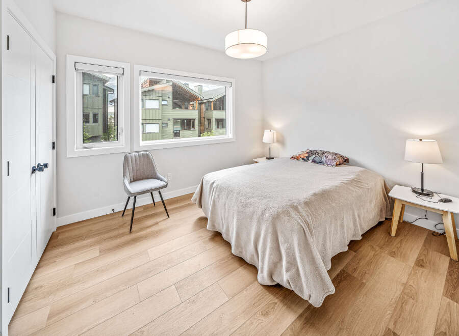 This bright bedroom features a comfortable bed with a decorative pillow and a cozy throw blanket.