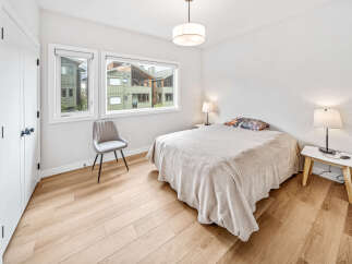 This bright bedroom features a comfortable bed with a decorative pillow and a cozy throw blanket.