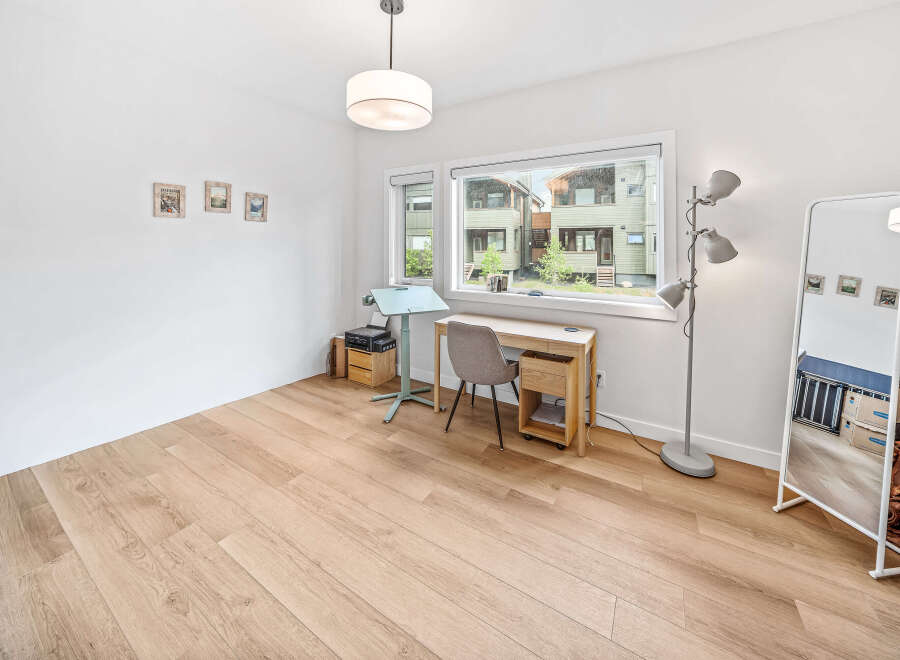 Bright and airy home office space featuring a modern desk and chair setup by a large window.