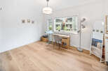 Bright and airy home office space featuring a modern desk and chair setup by a large window.