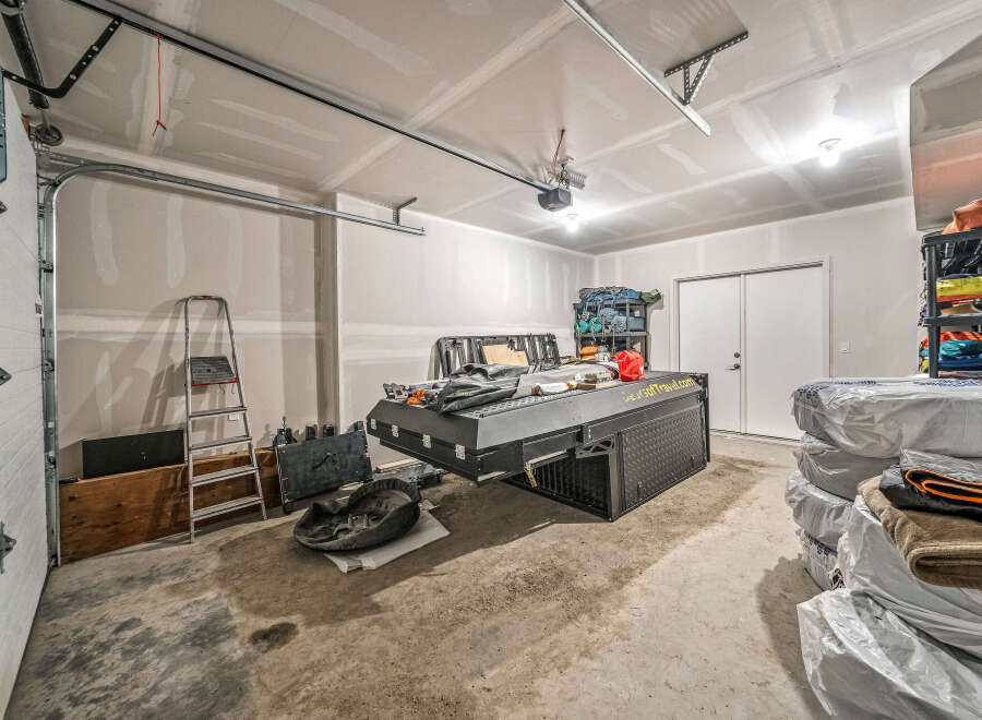 Discover ample storage and organization potential in this spacious garage, perfect for your vehicles and recreational gear.