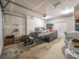 Discover ample storage and organization potential in this spacious garage, perfect for your vehicles and recreational gear.