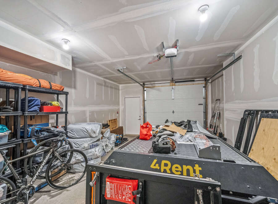 This spacious garage offers ample storage solutions with multi-tiered shelving units perfect for organizing tools and equipment.