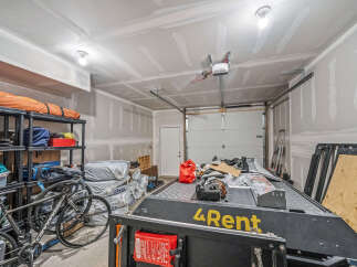 This spacious garage offers ample storage solutions with multi-tiered shelving units perfect for organizing tools and equipment.