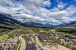 Experience mountain living in this stunning aerial view of a modern residential community nestled amidst the majestic Rocky Mountains.