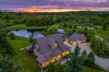 Experience serene country living with this stunning property featuring a charming home and a detached garage, nestled amidst lush greenery and tranquil ponds.