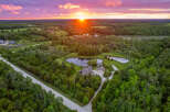 Experience serene country living with this stunning aerial view of a sprawling estate at sunset.