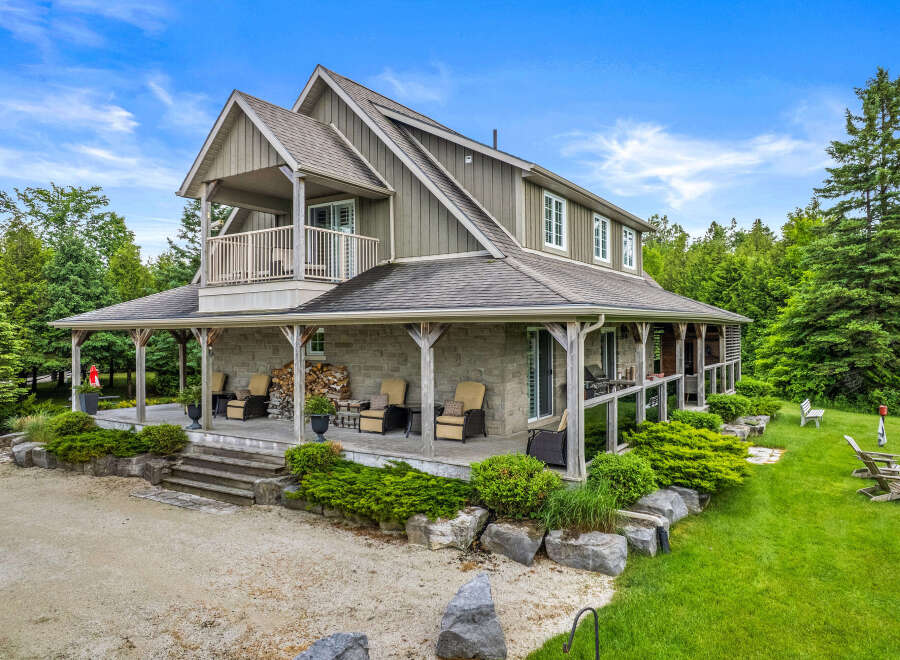 Experience luxury living in this stunning home featuring a wrap-around porch and a private balcony, perfect for enjoying the serene surroundings.