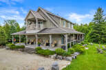 Experience luxury living in this stunning home featuring a wrap-around porch and a private balcony, perfect for enjoying the serene surroundings.