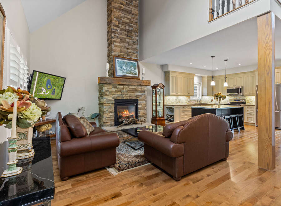 Experience luxury living in this stunning home featuring a grand stone fireplace as the centerpiece of the living room.