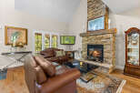Experience luxury living in this stunning living room, featuring a grand stone fireplace as the centerpiece.
