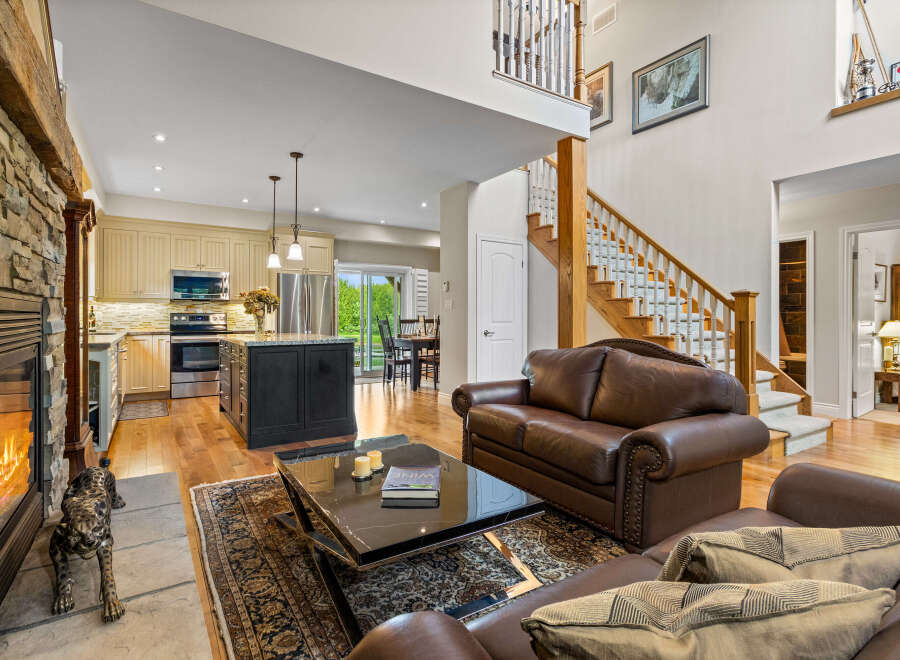 Experience luxurious living in this spacious open-concept home, featuring a stunning stone fireplace and a gourmet kitchen with a large island.