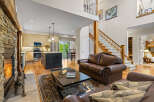 Experience luxurious living in this spacious open-concept home, featuring a stunning stone fireplace and a gourmet kitchen with a large island.