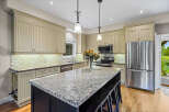 This spacious kitchen boasts custom cabinetry with beadboard detailing and elegant crown molding.