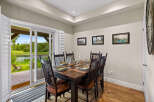 Enjoy elegant dining with a view in this beautifully set dining room, featuring a dark wood table and chairs ready for guests.