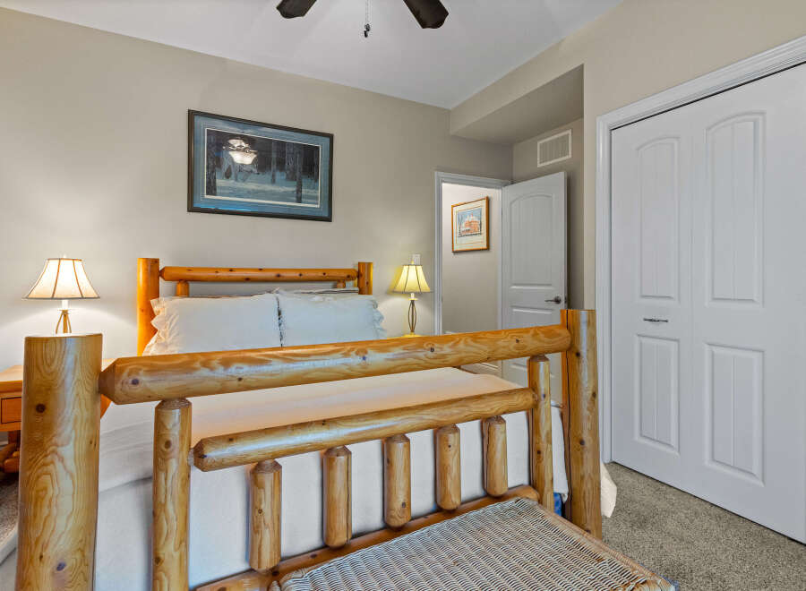 Experience rustic charm in this cozy bedroom featuring a beautiful log bed frame and matching nightstands.