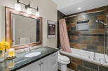 This elegant bathroom features a spacious vanity with a granite countertop and a large, ornate mirror.