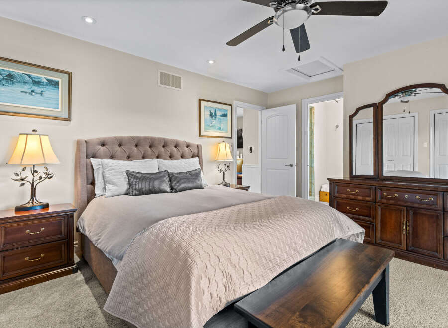 Experience ultimate comfort in this beautifully appointed bedroom, featuring a plush tufted headboard and a luxurious quilted bedspread.