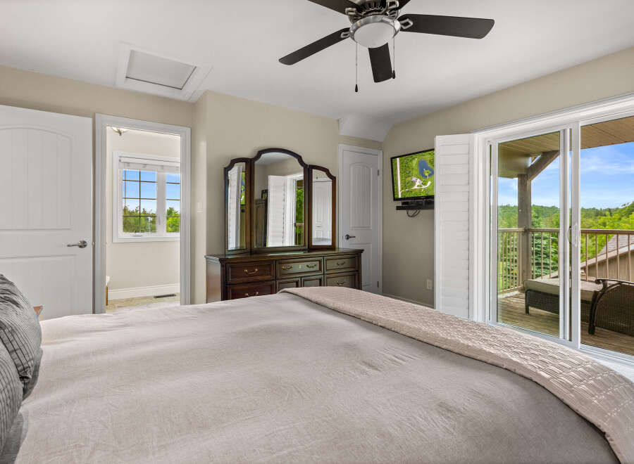 Experience luxurious living in this stunning bedroom featuring a plush king-sized bed and elegant dark wood dresser with a tri-fold mirror.