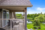 Enjoy serene waterfront living from this charming property, featuring a private balcony overlooking a tranquil lake and lush greenery.